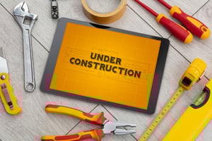 Tablet and tools with home under construction concept Tablet and tools with home under construction concept